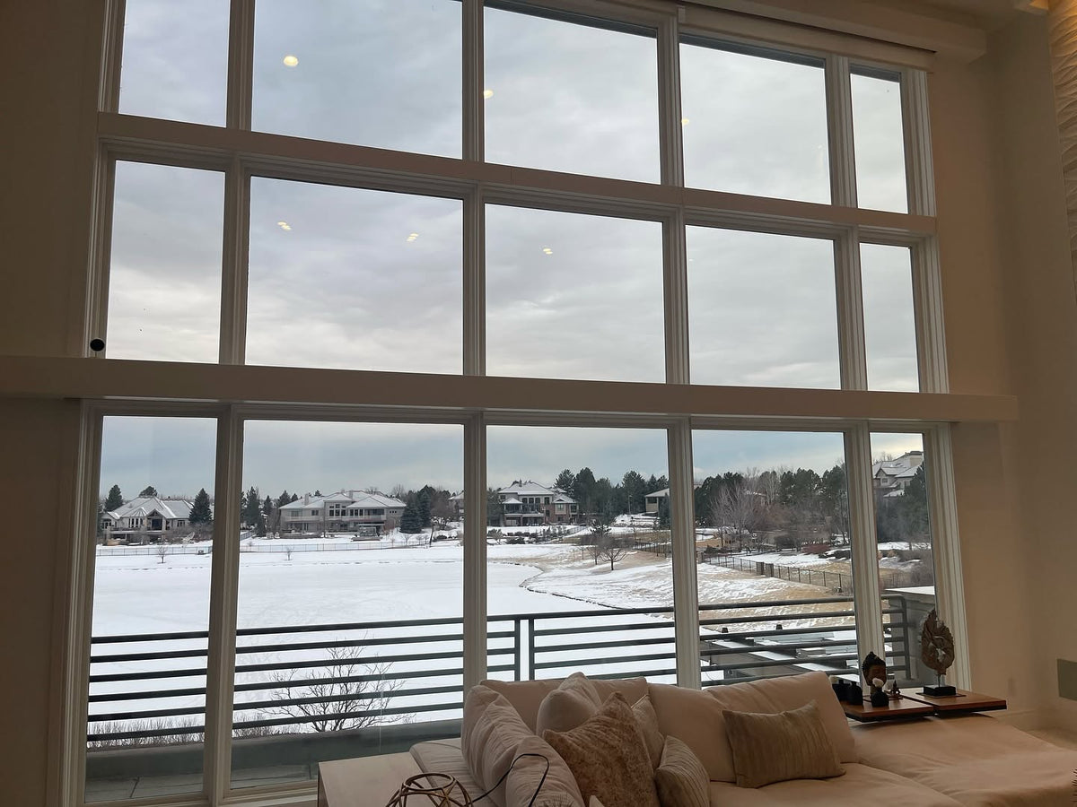 Living room with large windows showing a snowy landscape before window tint. keep the view without the need of shades or blinds
