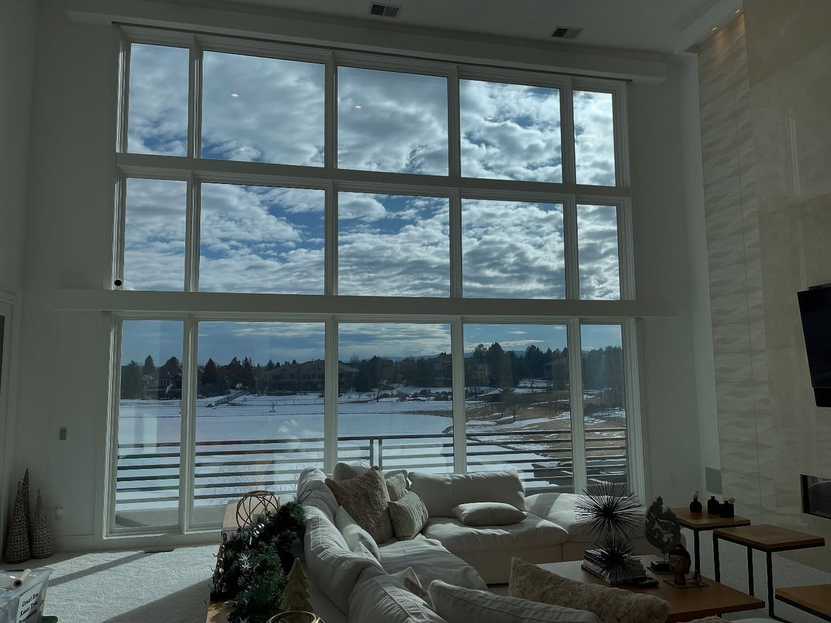 Living room with large windows showing a snowy landscape after window tint application from turbo tint. cool the room down without blocking the view. 