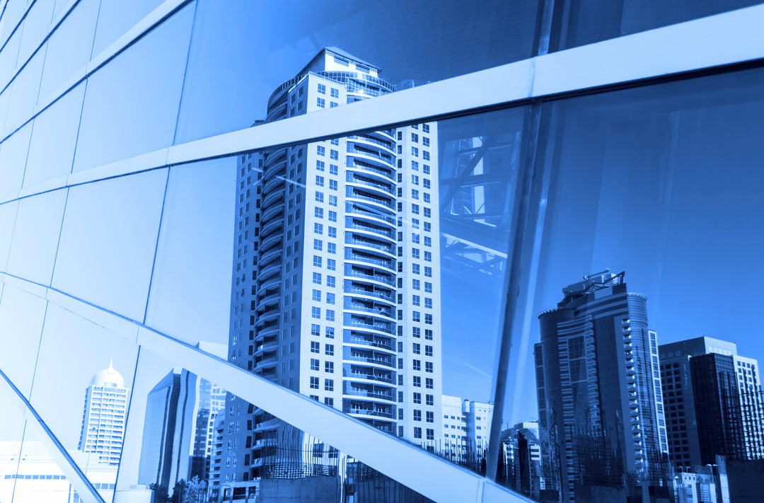 Cityscape reflection in a glass building with window tint for glare reduction and employee comfort 